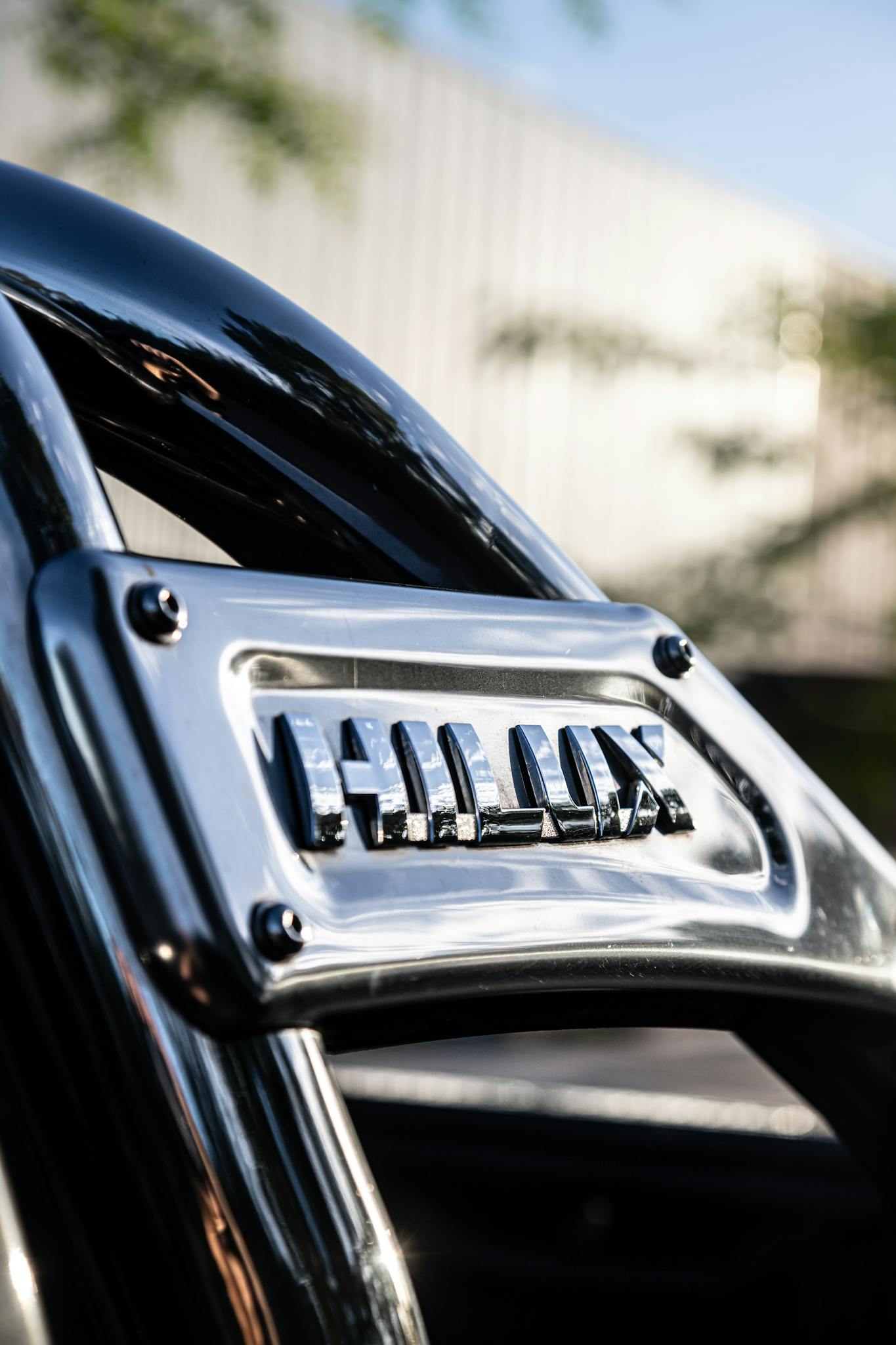 Detailed close-up of a chrome Hilux bar on a Toyota vehicle outdoors.